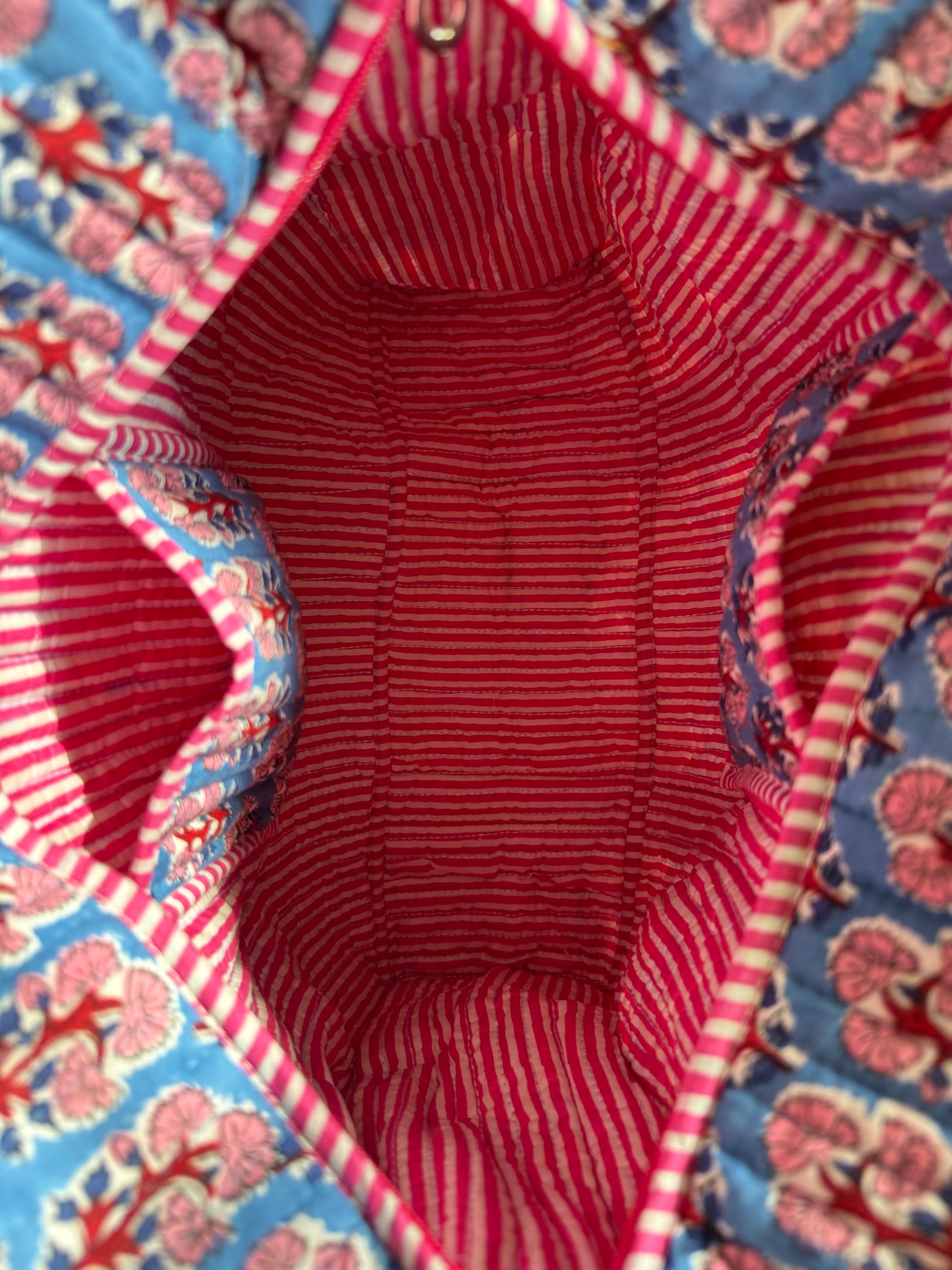 House of Mulmul - Cotton Tote Bag, Travel Bag. Close-up of a fabric interior with pockets and red and white stripes on a floral-patterned exterior.