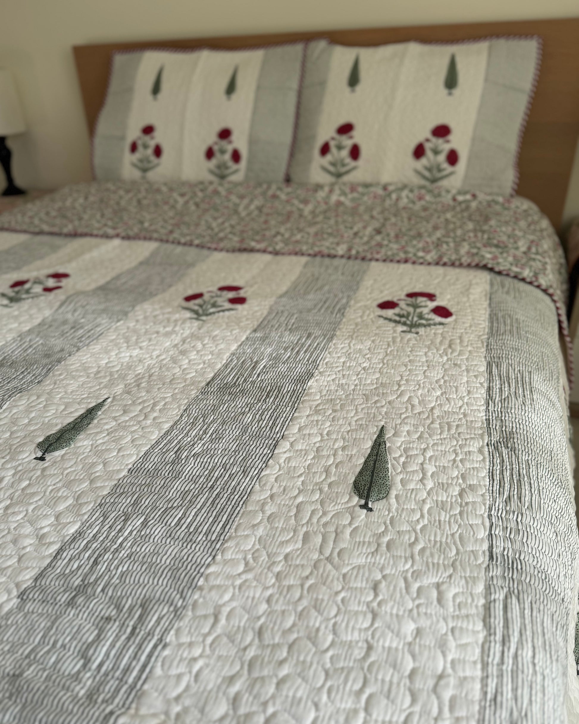 House of Mulmul - Blockprinted Cotton Bedcover Reversible Muslin. Cotton bedcover with floral patterns on a bed