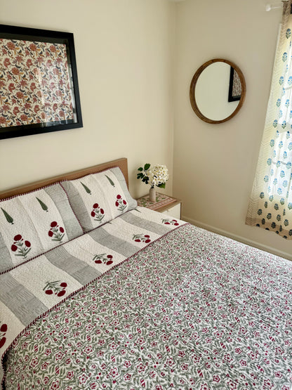 House of Mulmul - Blockprinted Cotton Bedcover Reversible Muslin. Bedroom with floral-patterned cotton bedspread, pillows, and decor elements.