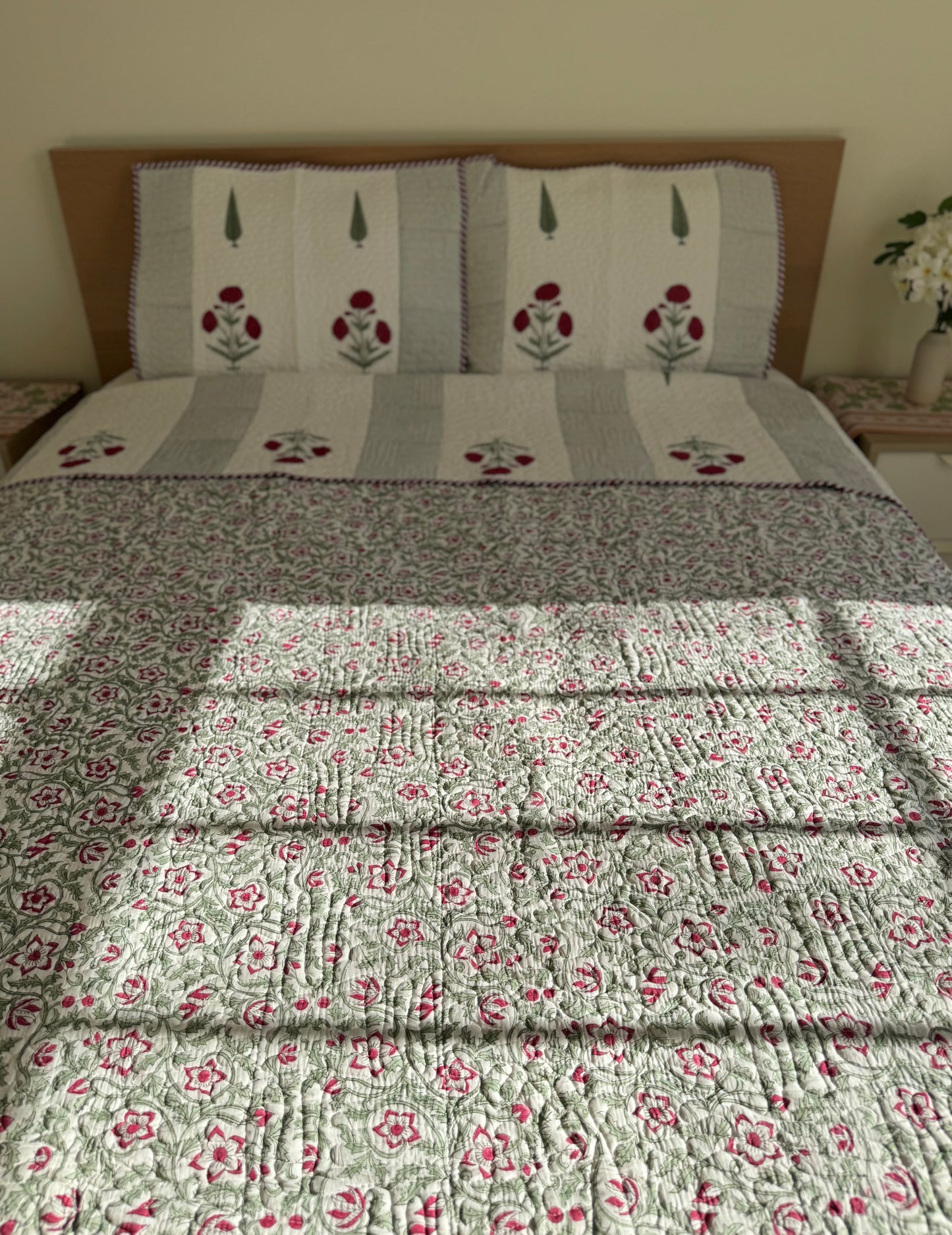 House of Mulmul - Blockprinted Cotton Bedcover Reversible Muslin. Floral-patterned cotton bedspread on a bed with a wooden headboard.