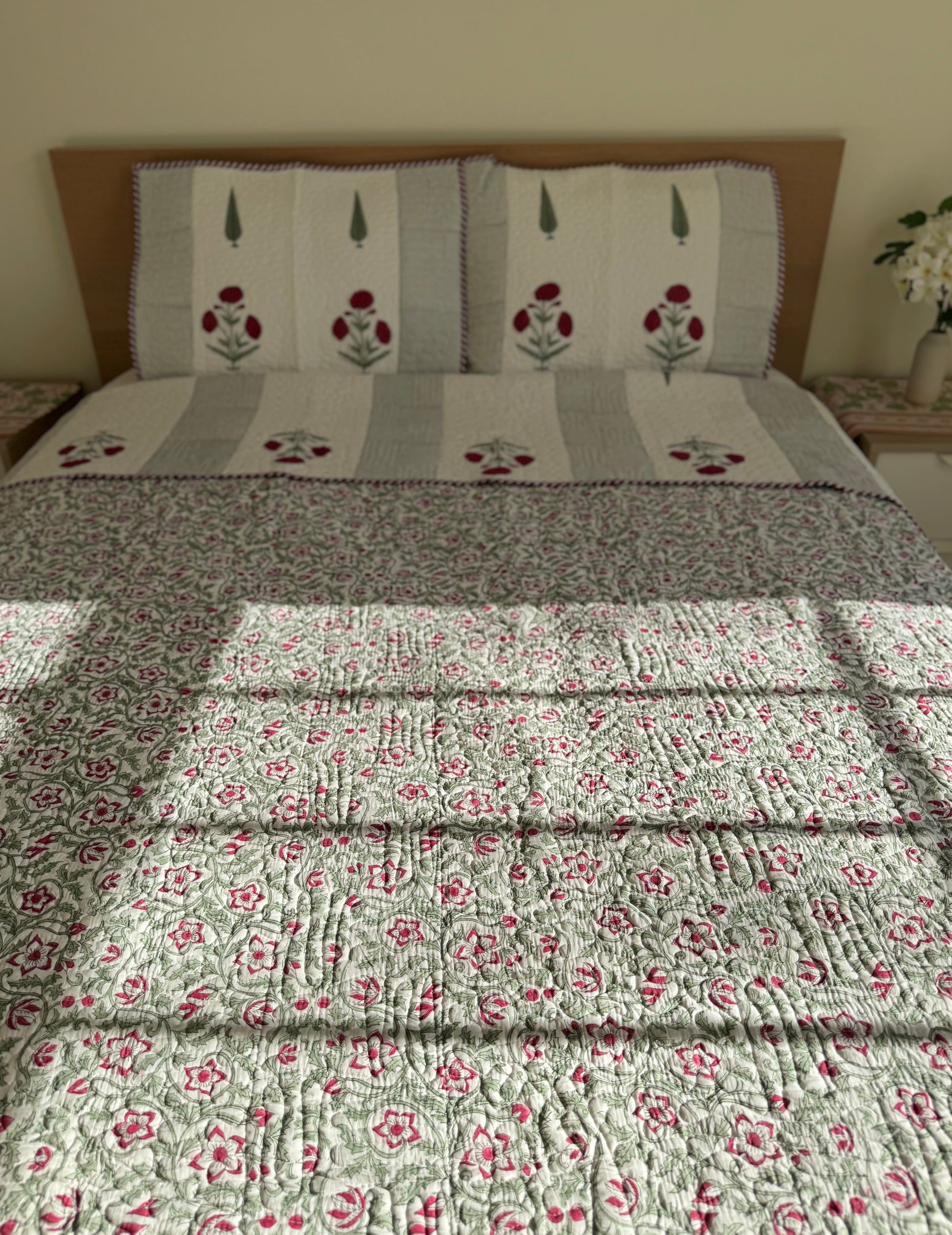 House of Mulmul - Blockprinted Cotton Bedcover Reversible Muslin. Floral-patterned cotton bedspread on a bed with a wooden headboard.