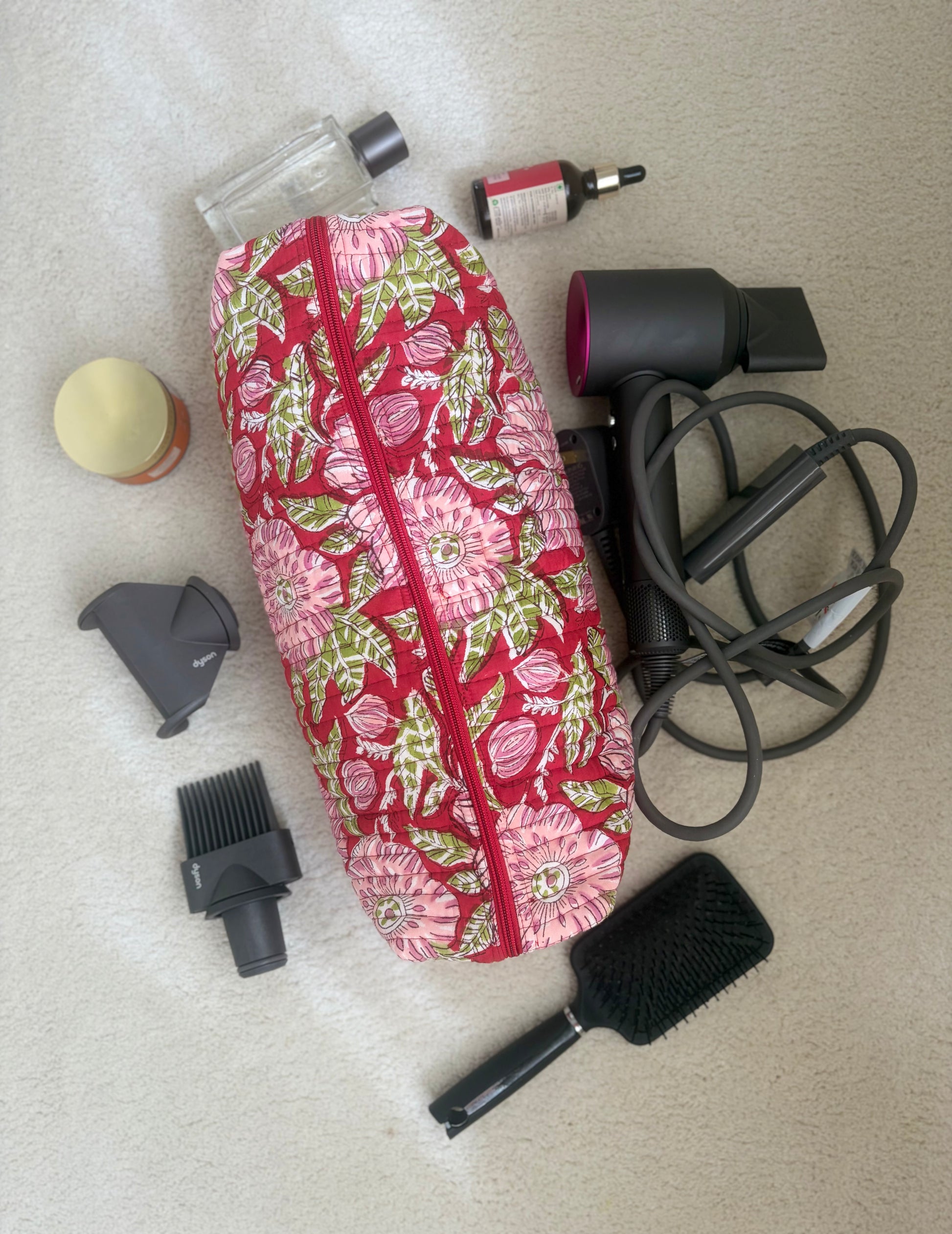 House of Mulmul - Blockprinted Cotton Hair Tool Bag. Floral-patterned Dyson hair dryer and straightener kit hair care tool bag and set on a beige surface.