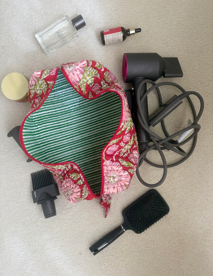 House of Mulmul - Blockprinted Cotton Hair Tool Bag. Dyson hair dryer and straightener kit hair care bag with products including a hair dryer, brush, and bottles on a beige surface.