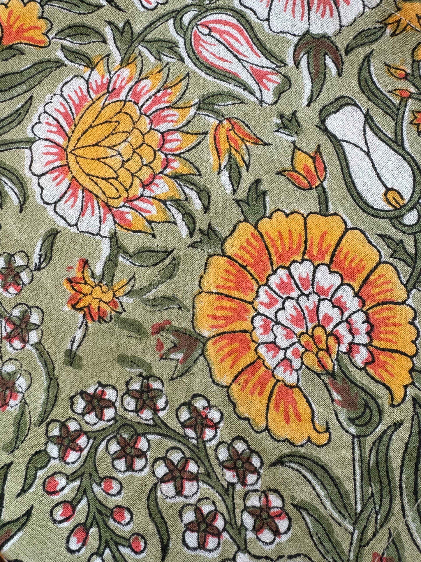 House of Mulmul - Blockprinted Cotton Napkins. Close-up of a floral pattern with yellow and pink flowers on a green background