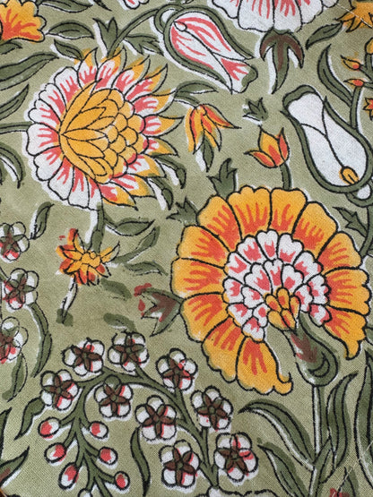 House of Mulmul - Blockprinted Cotton Napkins. Close-up of a floral pattern with yellow and pink flowers on a green background