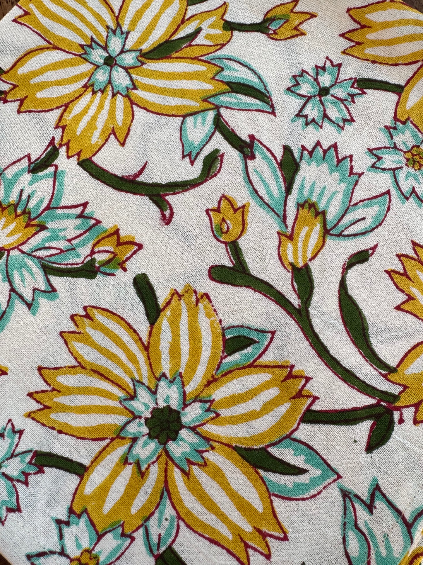 House of Mulmul - Blockprinted Cotton Napkins. Close-up of floral fabric pattern with yellow and green flowers on a white background