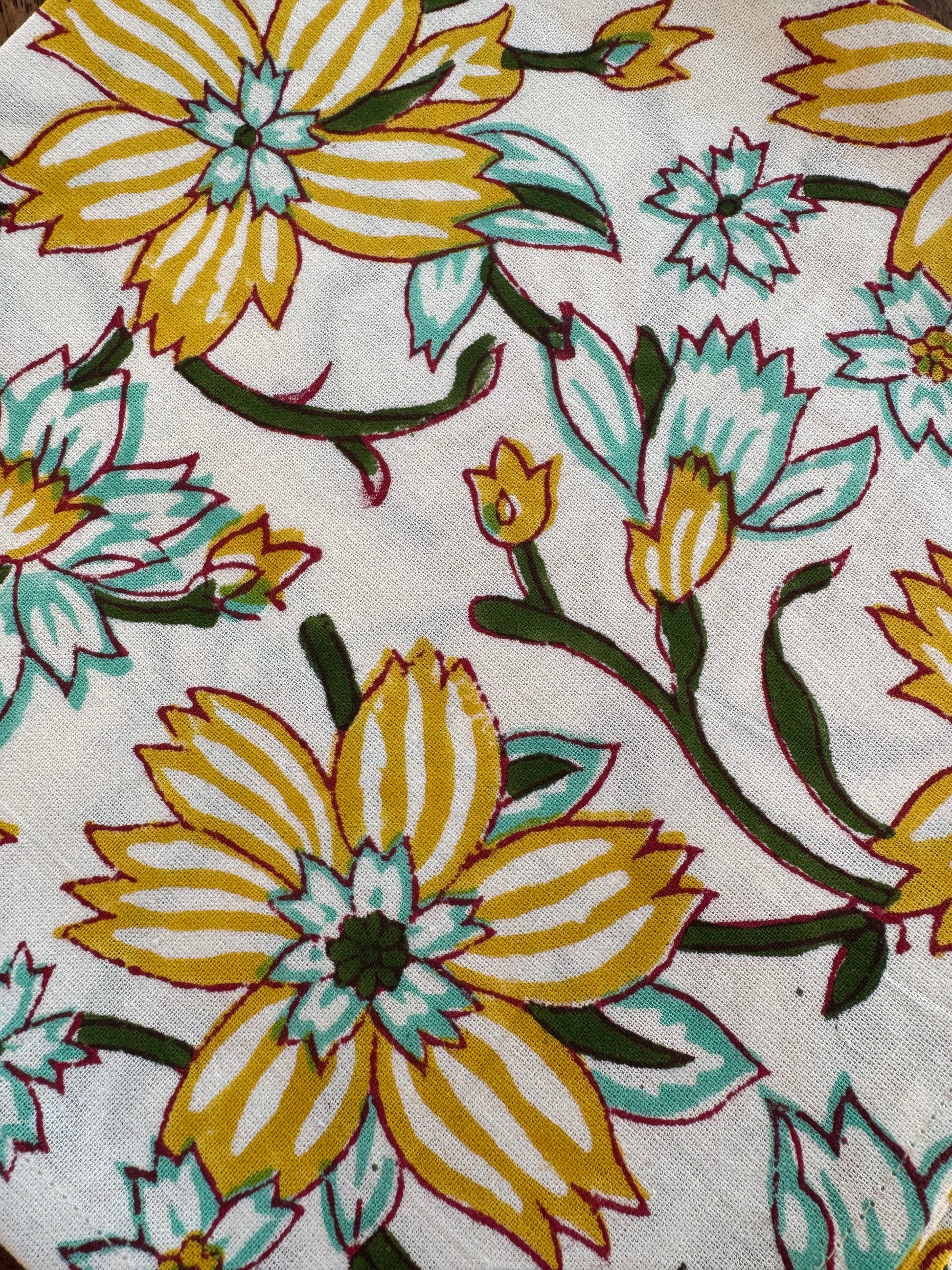 House of Mulmul - Blockprinted Cotton Napkins. Close-up of floral fabric pattern with yellow and green flowers on a white background