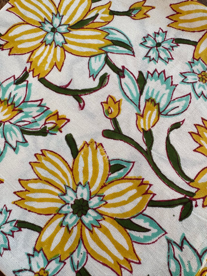 House of Mulmul - Blockprinted Cotton Napkins. Close-up of floral fabric pattern with yellow and green flowers on a white background