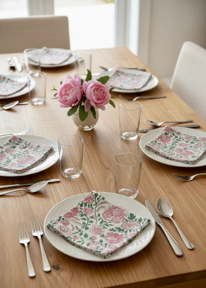 House of Mulmul - Blockprinted Cotton Napkins. Dining table set with floral plates, napkins, and glasses in a bright room.