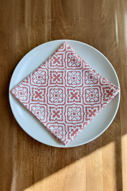 House of Mulmul - Blockprinted Cotton Napkins. Red patterned napkin on a white plate on a wooden table.