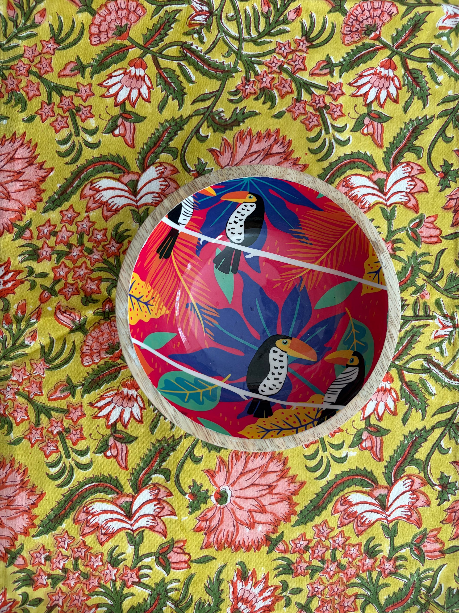 House of Mulmul - Blockprinted Cotton Reversible Table Runner & Mats set. Colorful woven basket with bird design on a floral patterned fabric background