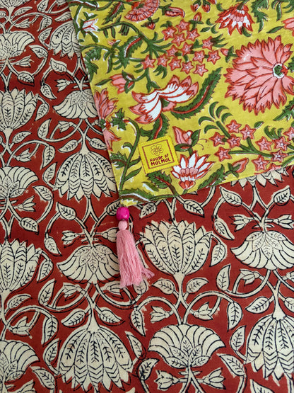 House of Mulmul - Blockprinted Cotton Reversible Table Runner & Mats set. Floral fabric with a tassel on a red and white patterned background