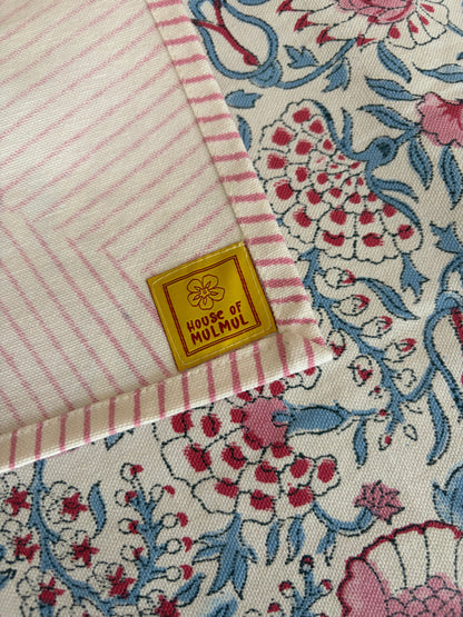 House of Mulmul - Blockprinted Cotton Table Cloth. Close-up of a fabric with floral patterns and a visible House of Mulmul brand label.