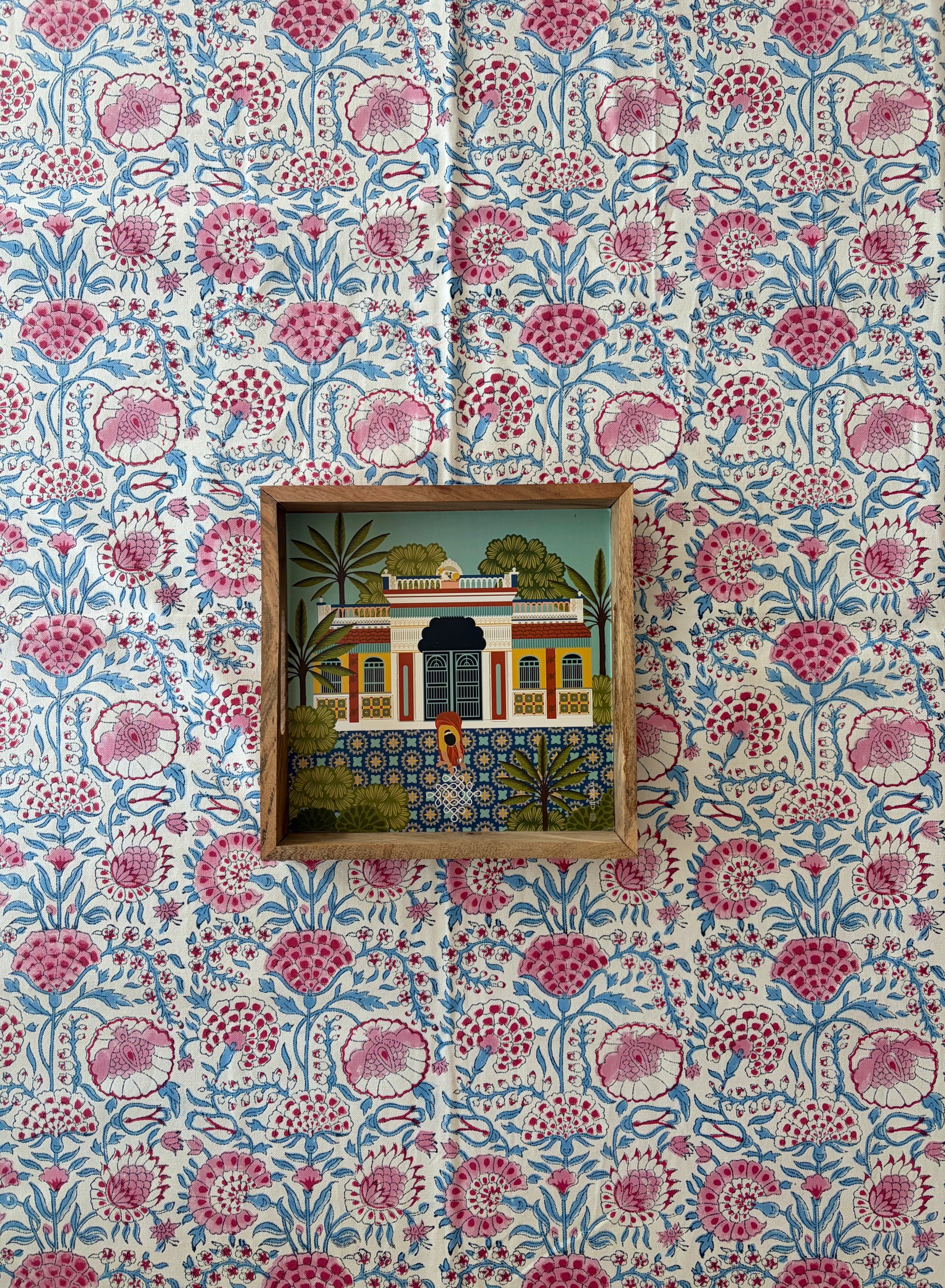 House of Mulmul - Blockprinted Cotton Table Cloth. Decorative wall with floral patterned wallpaper and framed artwork.