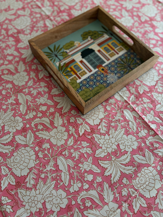 House of Mulmul - Blockprinted Cotton Table Cloth. Wooden tray with a embroidered scene on a pink floral tablecloth background