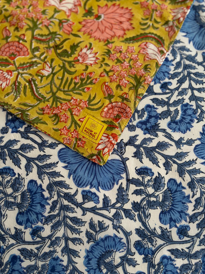 House of Mulmul - Blockprinted Cotton Reversible Table Runner & Placemats set. Close-up of floral fabric with yellow, blue, and white patterns.