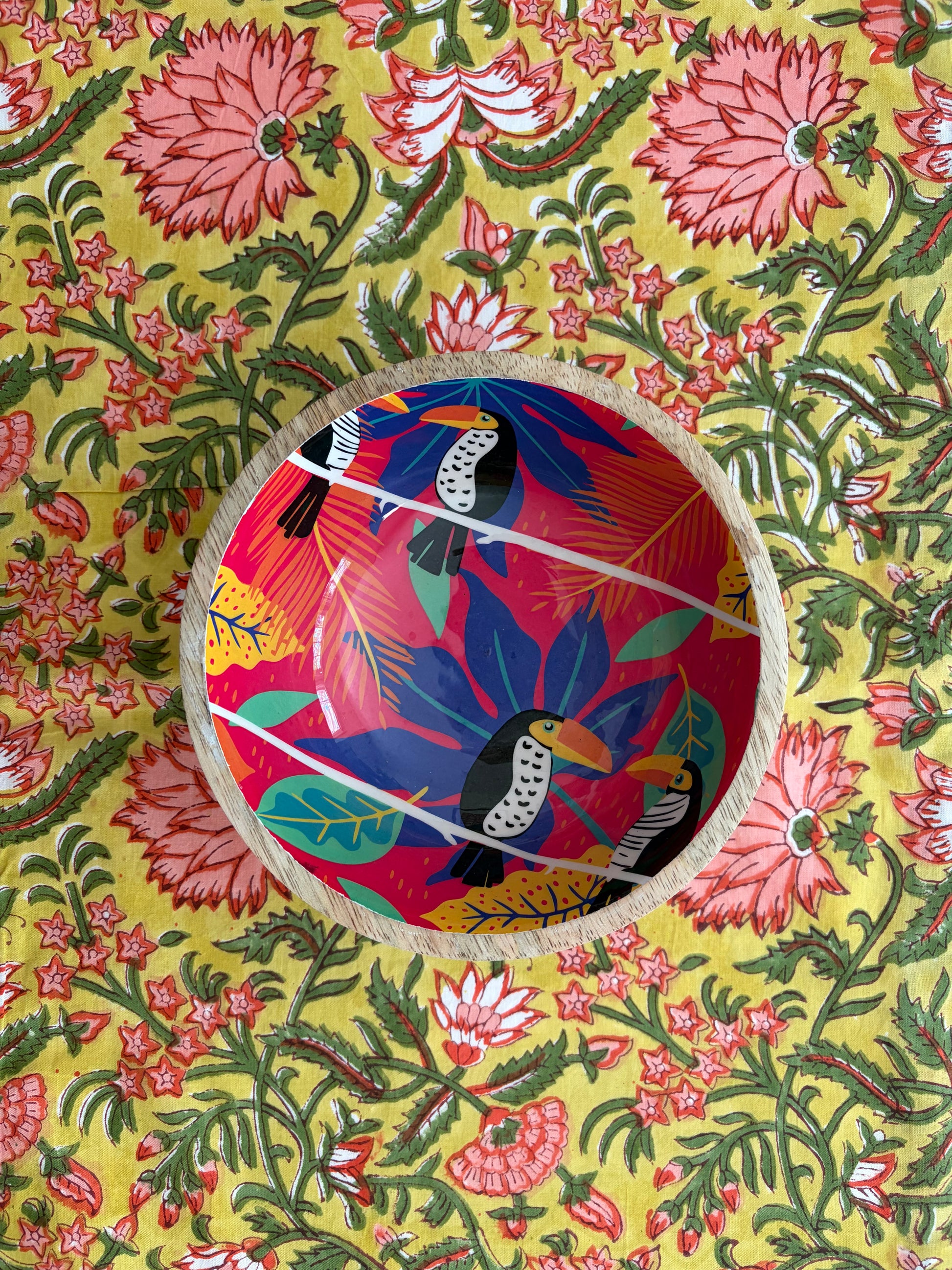 House of Mulmul - Blockprinted Cotton Reversible Table Runner & Placemats set. Colorful fabric with floral patterns and a circular cutout showing a bird design.