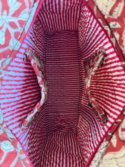 House of Mulmul - Blockprinted Cotton Tote Bags. Close-up of the interior of a red and white striped fabric tote bag, showing patterned fabric lining and side handles.