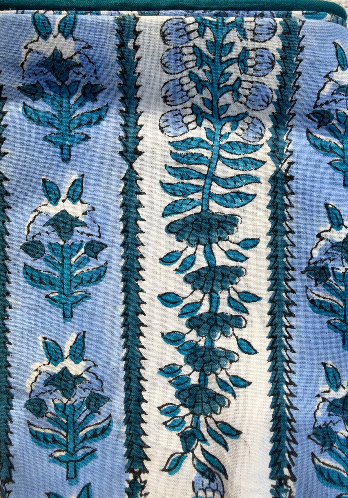 House of Mulmul - Blockprinted Cushion Covers-Pillow Cases. A close-up of a patterned textile featuring vertical bands of light blue, white, and teal floral motifs with serrated borders.