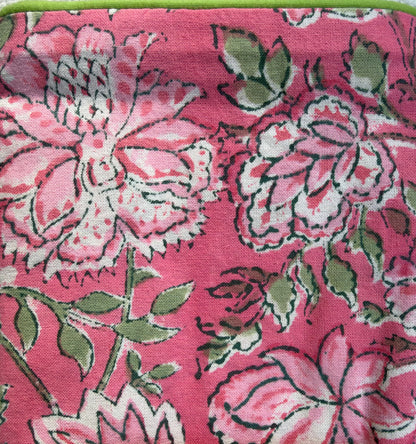 House of Mulmul - Blockprinted Cushion Covers-Pillow Cases. A close-up of a pink fabric with a bold floral block print pattern in pink, white, and green.