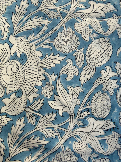House of Mulmul - Blockprinted Cushion Covers-Pillow Cases. A close-up of a fabric or wallpaper pattern featuring a classic botanical design in blue and off-white. The pattern includes stylized flowers, leaves, and thistle-like elements with detailed stippling and linework.