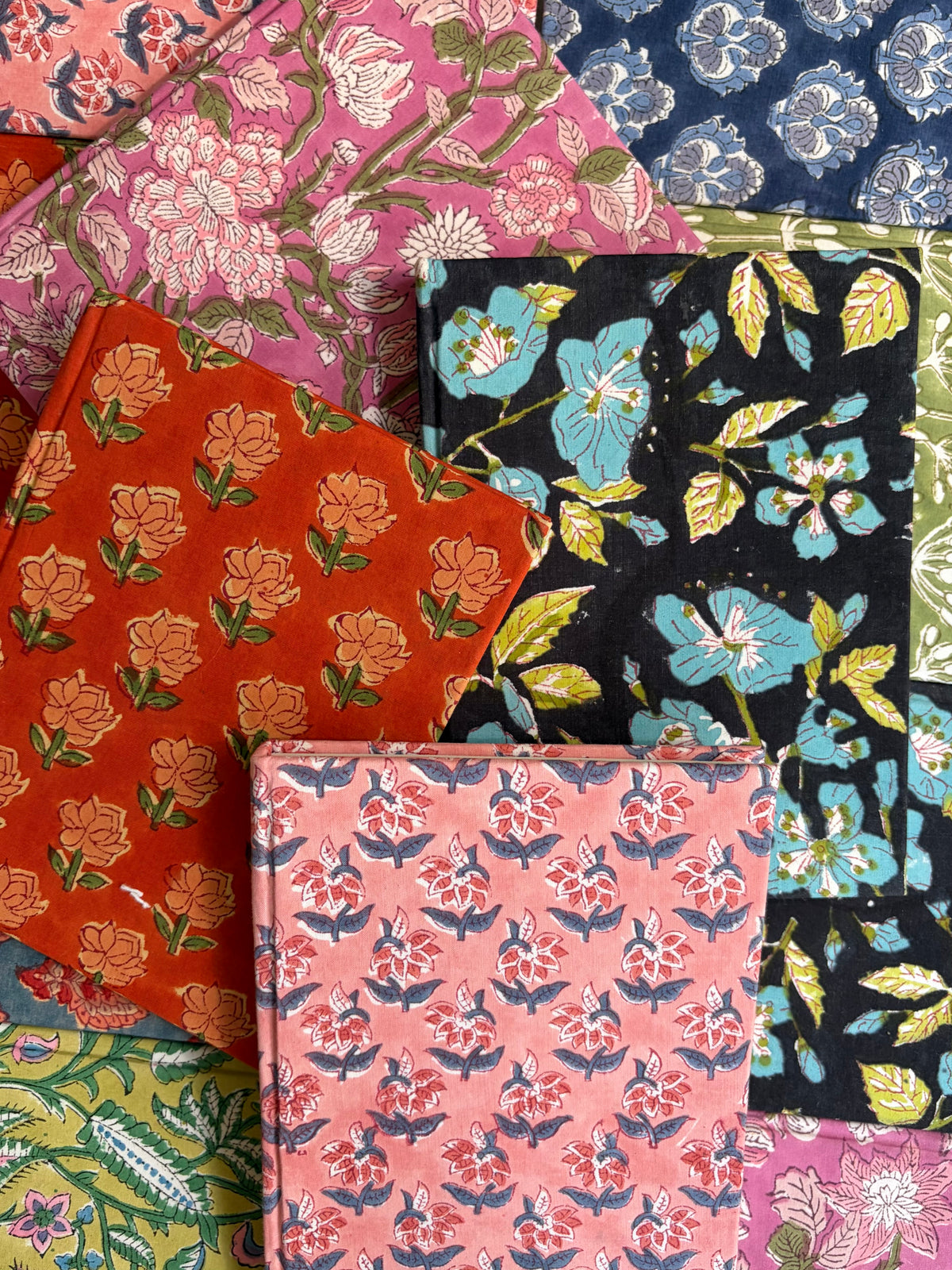 House of Mulmul - Blockprinted Journal Diary Notebook. A stack of colorful patterned notebooks or journals with floral and bird block-print designs in pink, orange, blue, black, green, and purple tones.