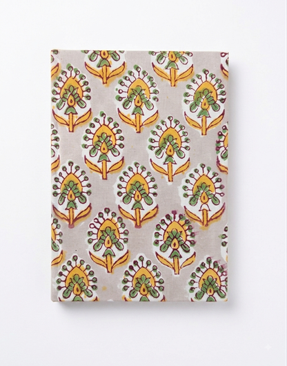 House of Mulmul - Blockprinted Journal Diary Notebook. A notebook with a repeating hand-painted style block print notebook in green, yellow, and orange on a light gray background, shown against a plain white backdrop.