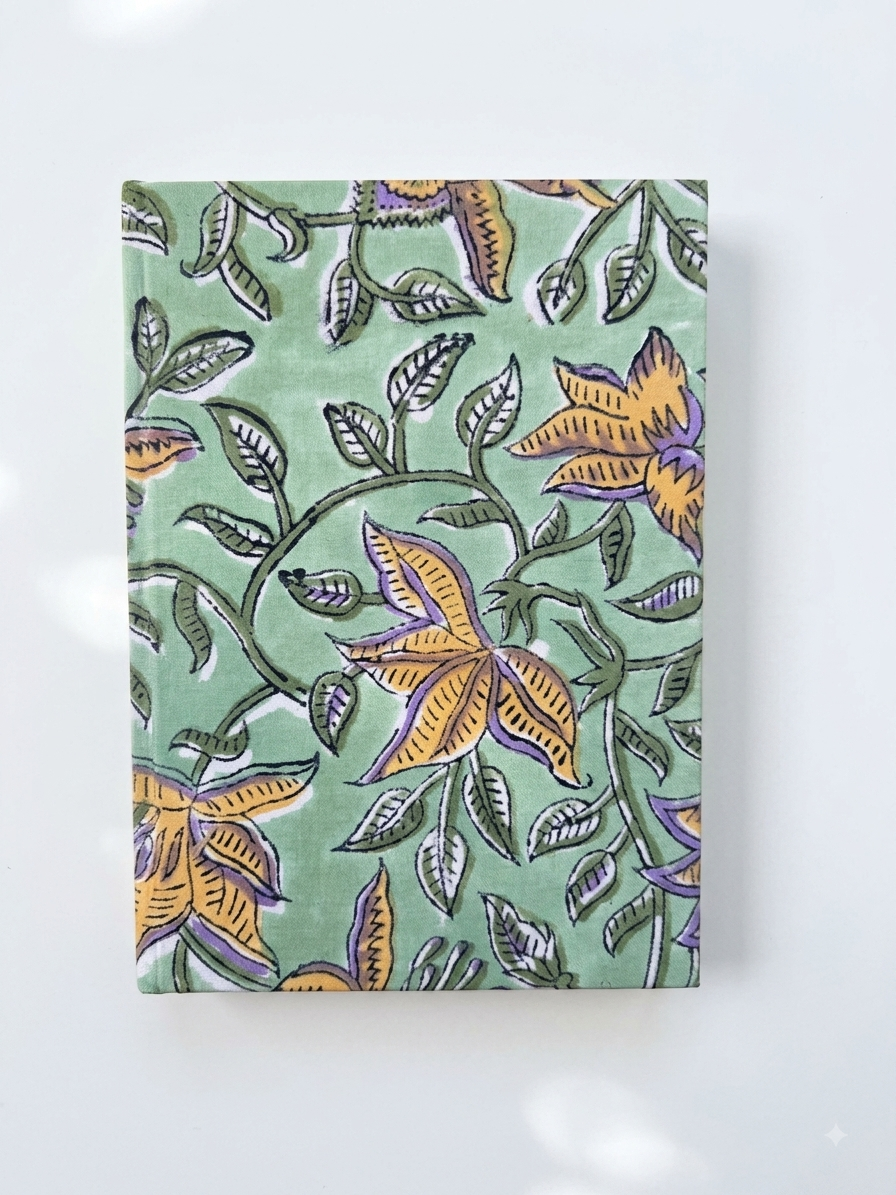 House of Mulmul - Blockprinted Journal Diary Notebook. A rectangular notebook or journal with a sage green cover featuring a hand-painted block print of yellow flowers and green leaves, displayed on a clean white background.