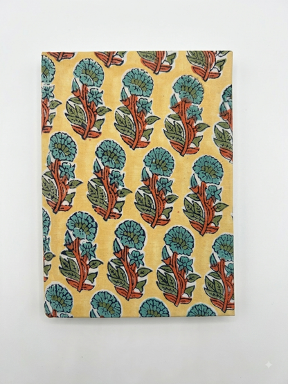House of Mulmul - Blockprinted Journal Diary Notebook. A notebook or journal with a vintage block-print style floral pattern on a pale yellow cover, photographed against a plain white background.