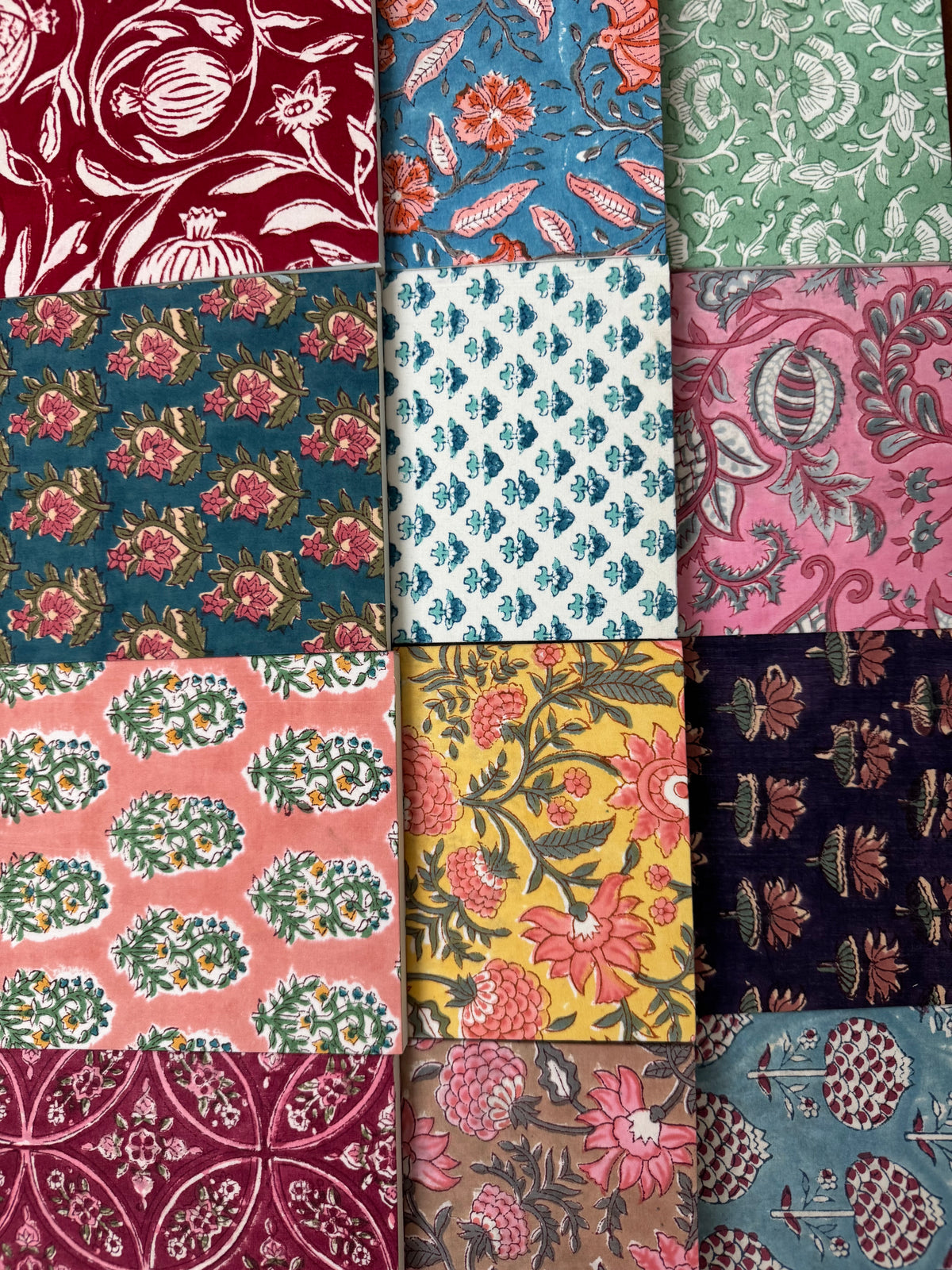 House of Mulmul - Blockprinted Journal Diary Notebook. A grid of twelve fabric or wallpaper swatches with various traditional block prints in multiple colors including red, blue, green, pink, yellow, and navy.