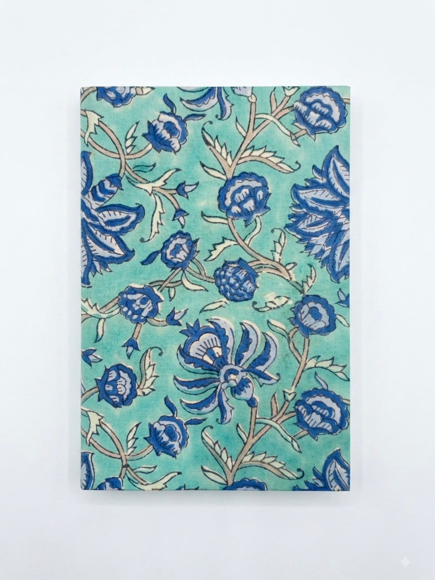 House of Mulmul - Blockprinted Journal Diary Notebook. A rectangular notebook or journal with a teal green cover featuring a blue and beige floral block print pattern, shown flat against a light gray background.