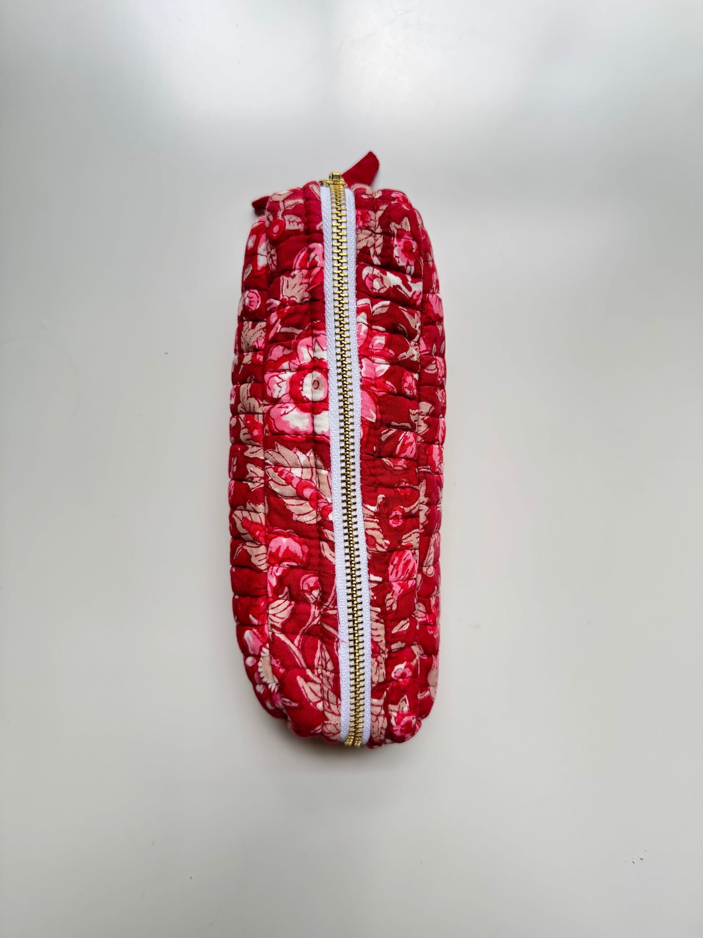House of Mulmul - Cotton Quilted Makeup Barrel Pouch. A red floral patterned zippered pouch with a gold zipper, photographed against a plain light gray background.