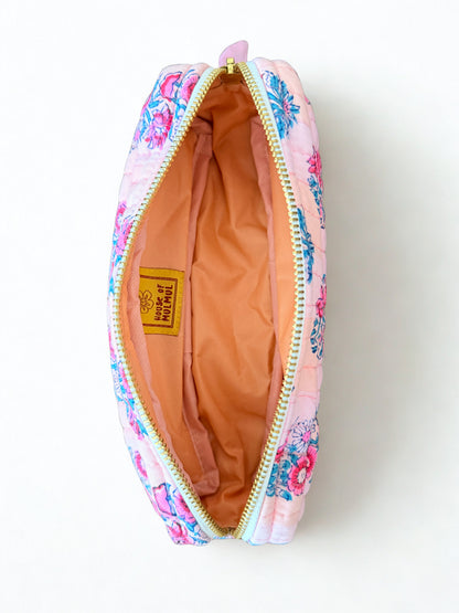 House of Mulmul - Cotton Quilted Makeup Barrel Pouch. A pink quilted cosmetic pouch with a colorful floral print, shown open to reveal a peach-colored interior lining and a yellow 'Peach All Natural' brand label.