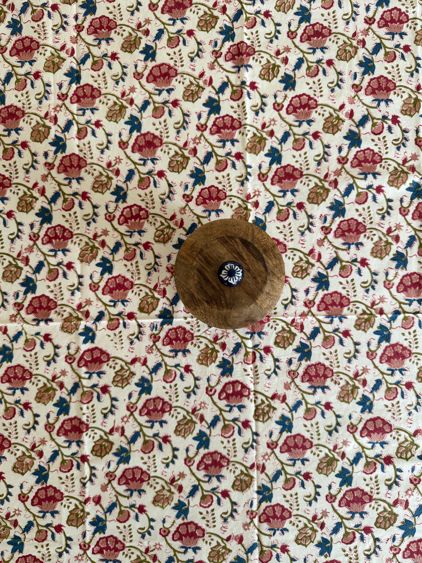 House of Mulmul - Cotton Table Cloth Round. Floral patterned fabric with a brown button in the center