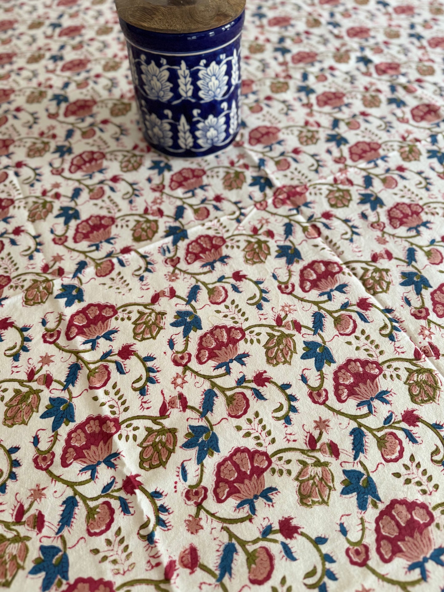 House of Mulmul - Cotton Table Cloth Round. Floral patterned fabric with a blue cup on top