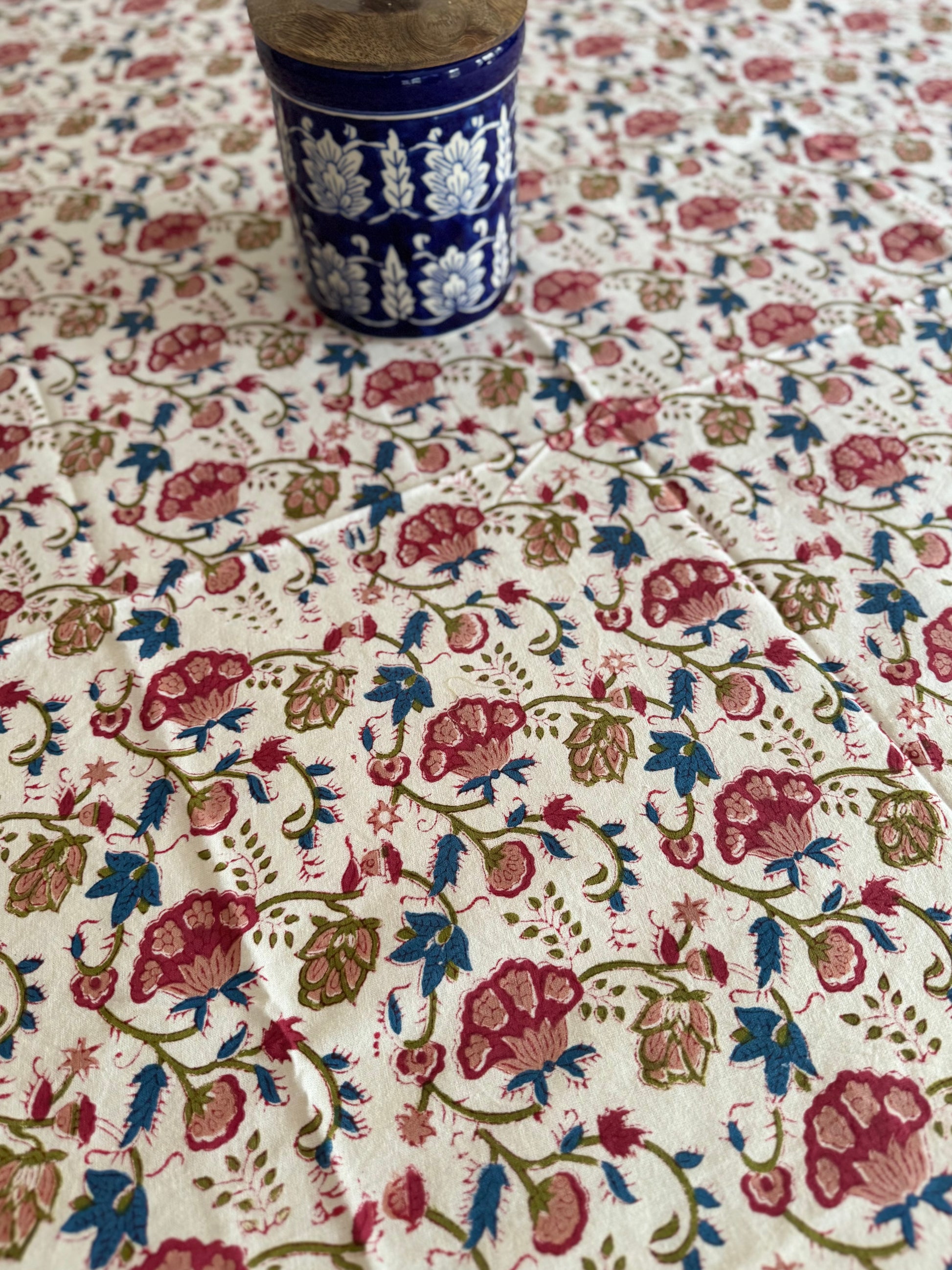 House of Mulmul - Cotton Table Cloth Round. Floral patterned fabric with a blue cup on top