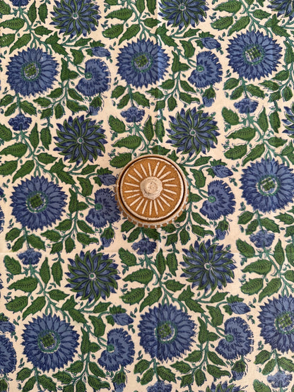 House of Mulmul - Cotton Table Cloth Round. Patterned fabric with blue flowers and green leaves on a beige background