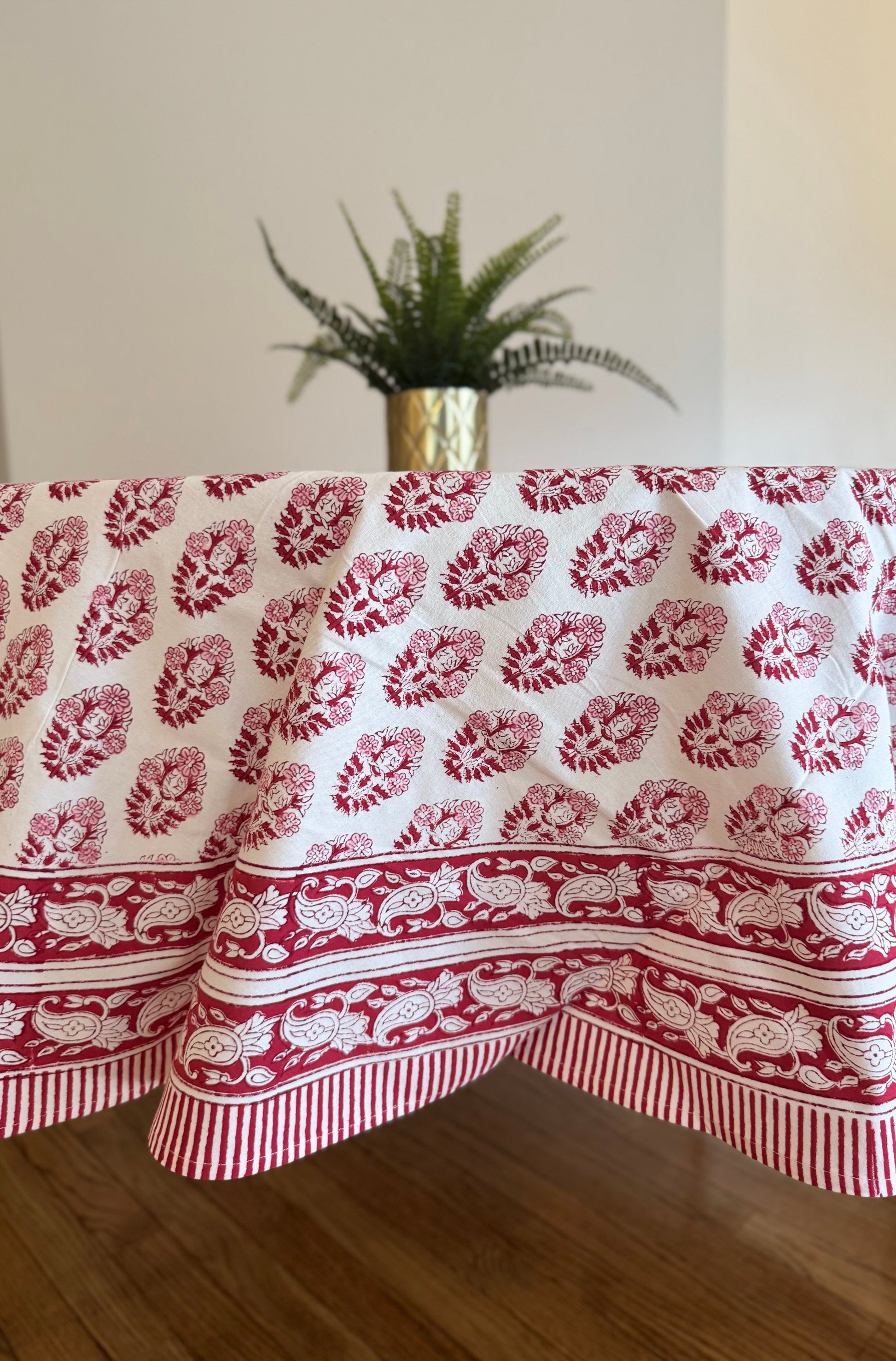 House of Mulmul - Cotton Table Cloth Round. Tablecloth with red floral pattern on a wooden table