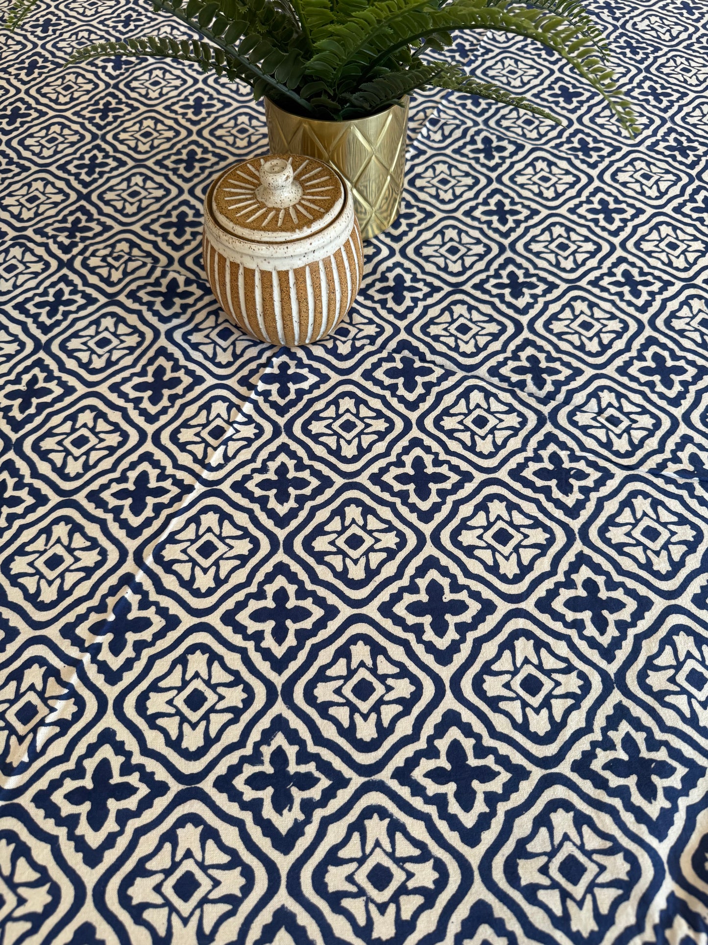 House of Mulmul - Cotton Table Cloth Round. Decorative vase on a patterned blue and white wall