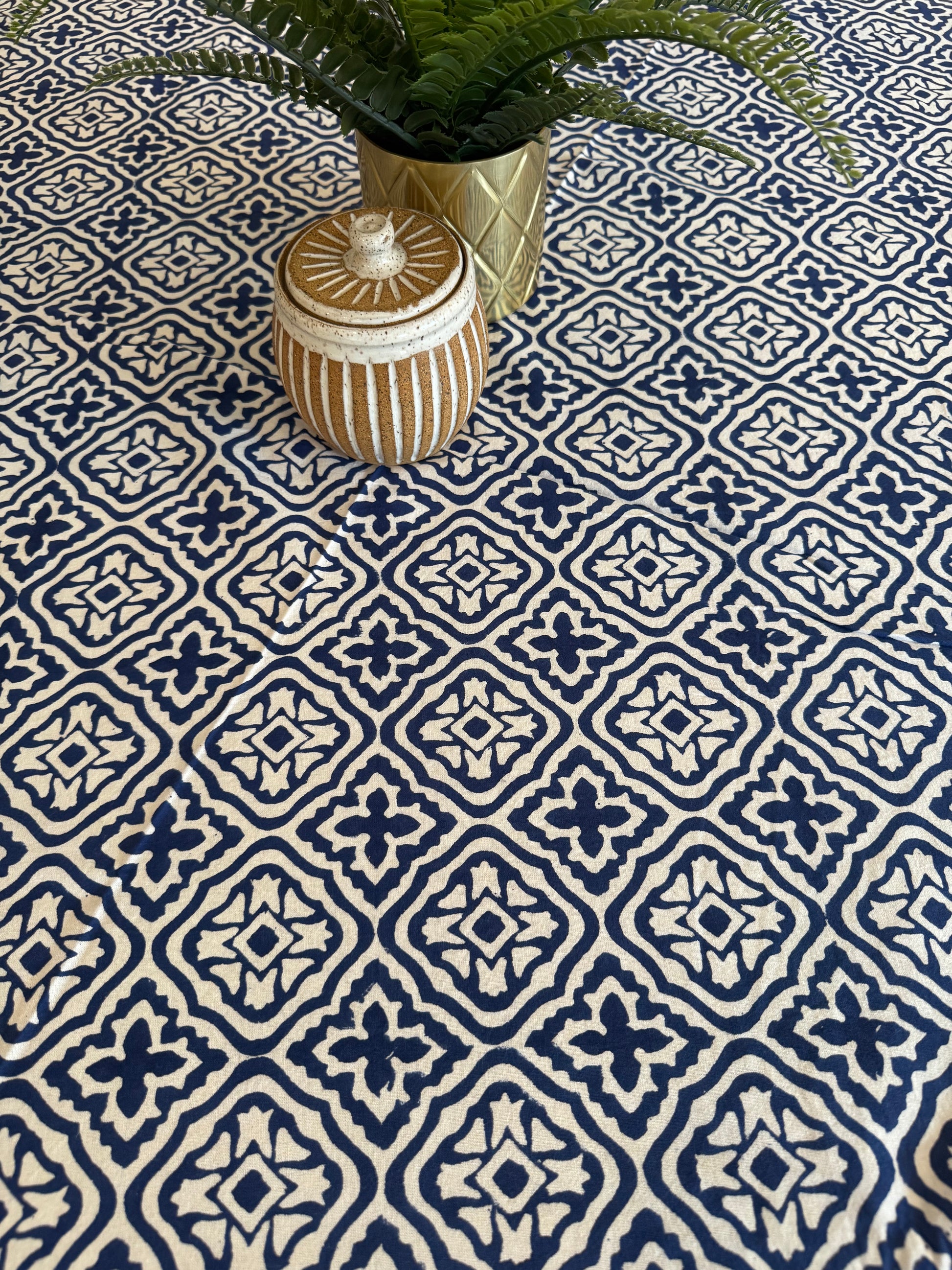 House of Mulmul - Cotton Table Cloth Round. Decorative vase on a patterned blue and white wall