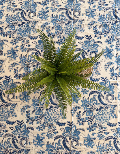 House of Mulmul - Cotton Table Cloth Round. Artificial fern plant on a blue and white patterned fabric background