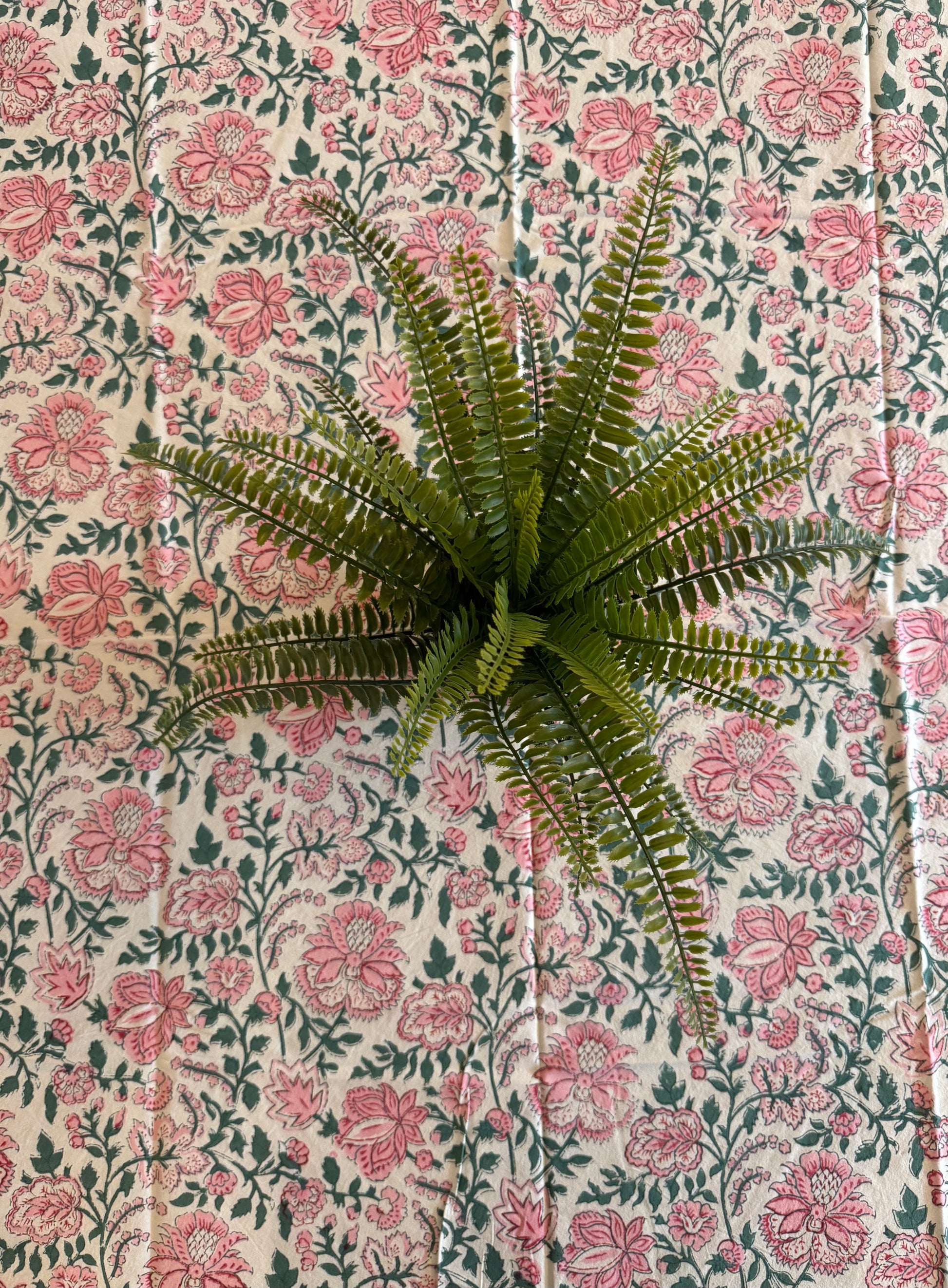 House of Mulmul - Cotton Table Cloth Round. Floral patterned tablecloth on a table with a plant.