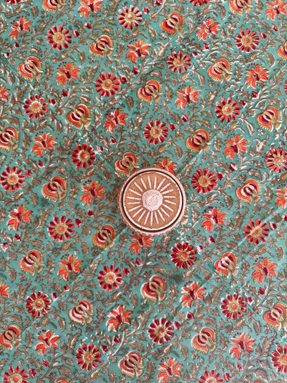 House of Mulmul - Cotton Table Cloth Round. Decorative fabric pattern with flowers and a central sun design on a teal background
