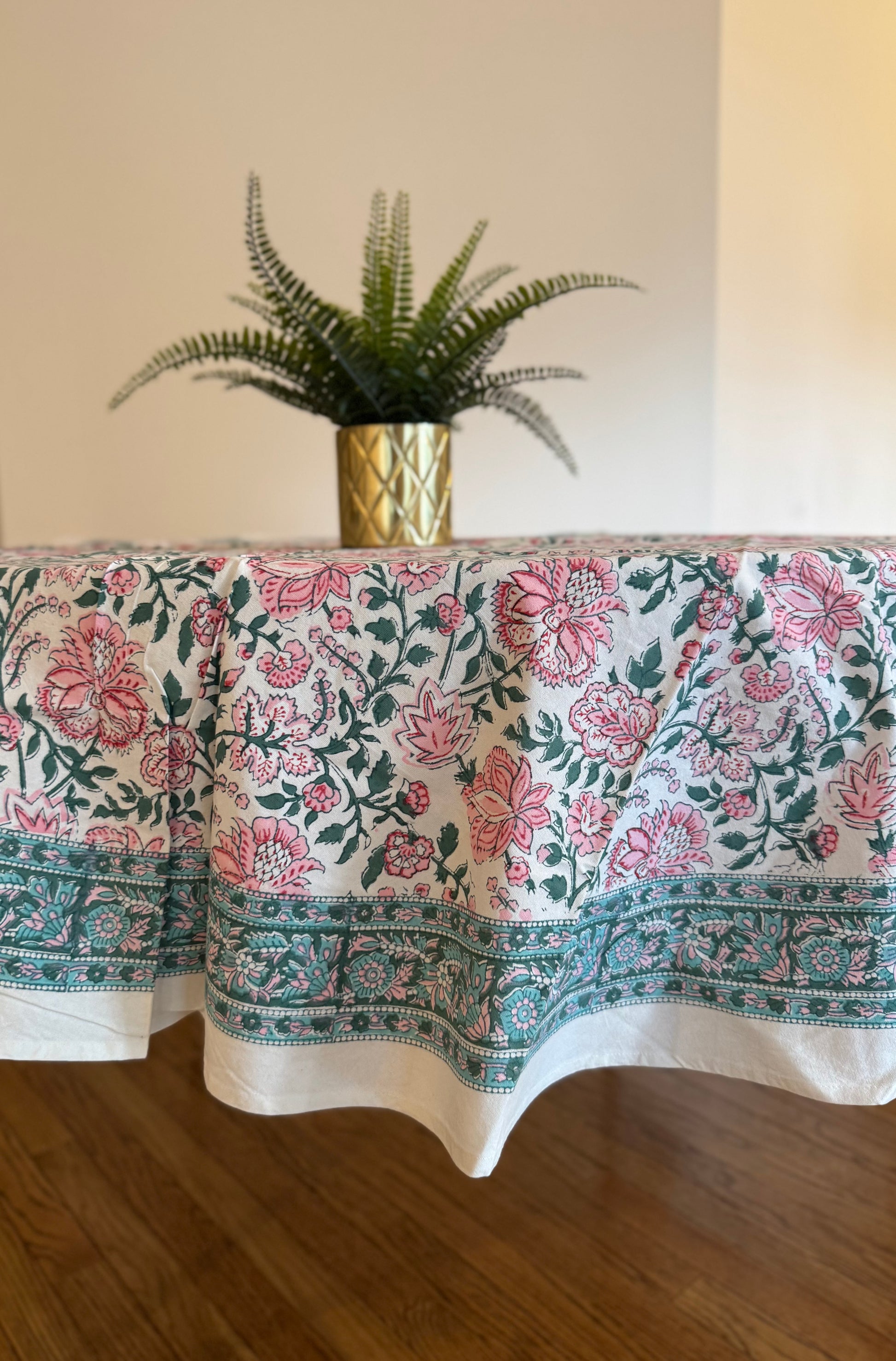 House of Mulmul - Cotton Table Cloth Round. Floral patterned tablecloth on a table with a plant in the background