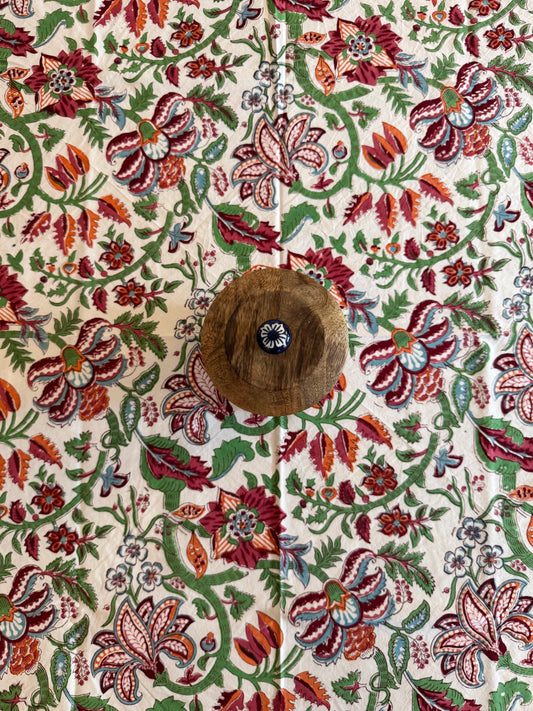 House of Mulmul - Cotton Table Cloth Round. Close-up of a table cloth with a floral pattern and a button.