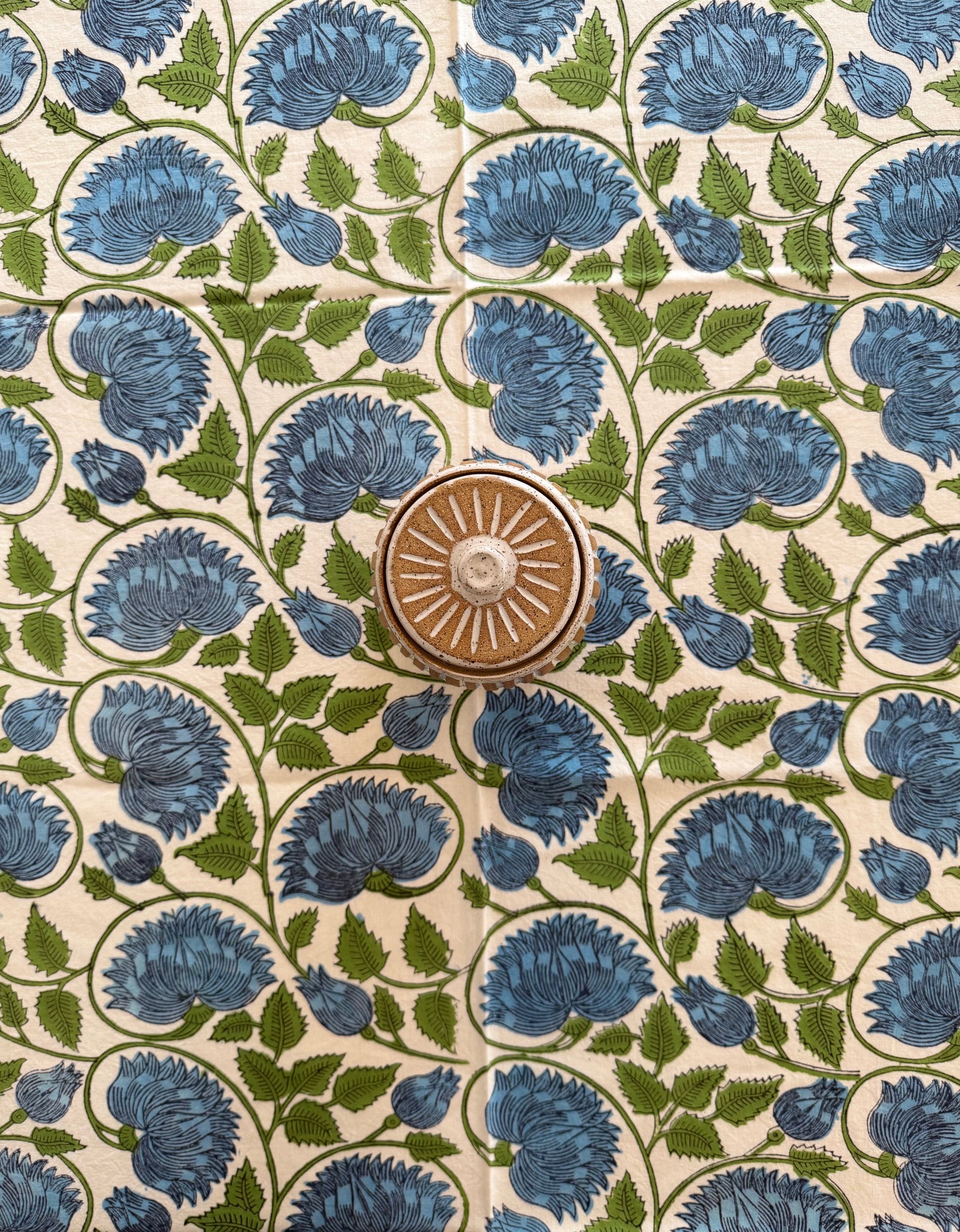 House of Mulmul - Cotton Table Cloth Round with green leaves, blue flower and white background pattern.