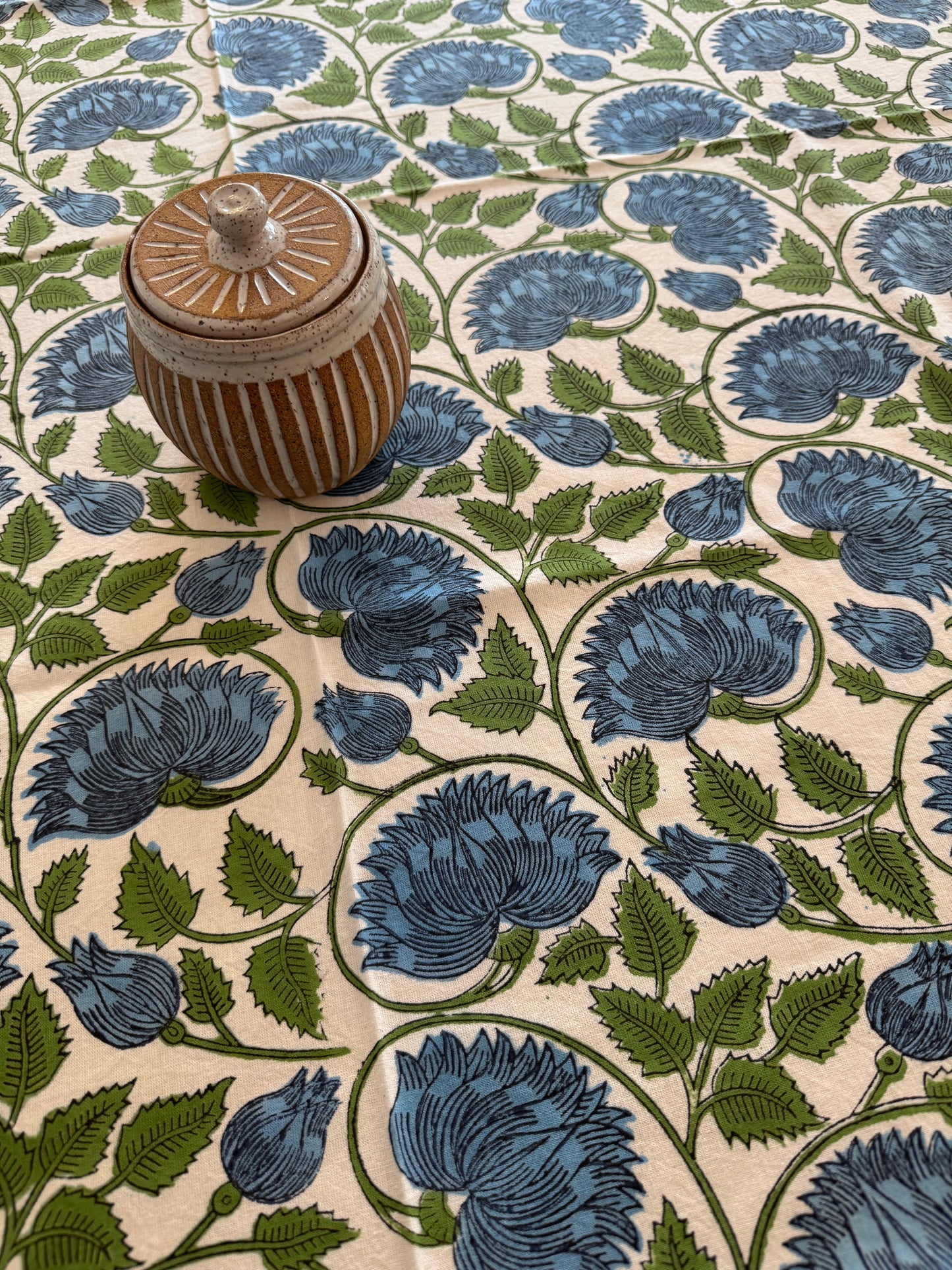 House of Mulmul - Cotton Table Cloth Round with green leaves, blue flower and white background pattern.