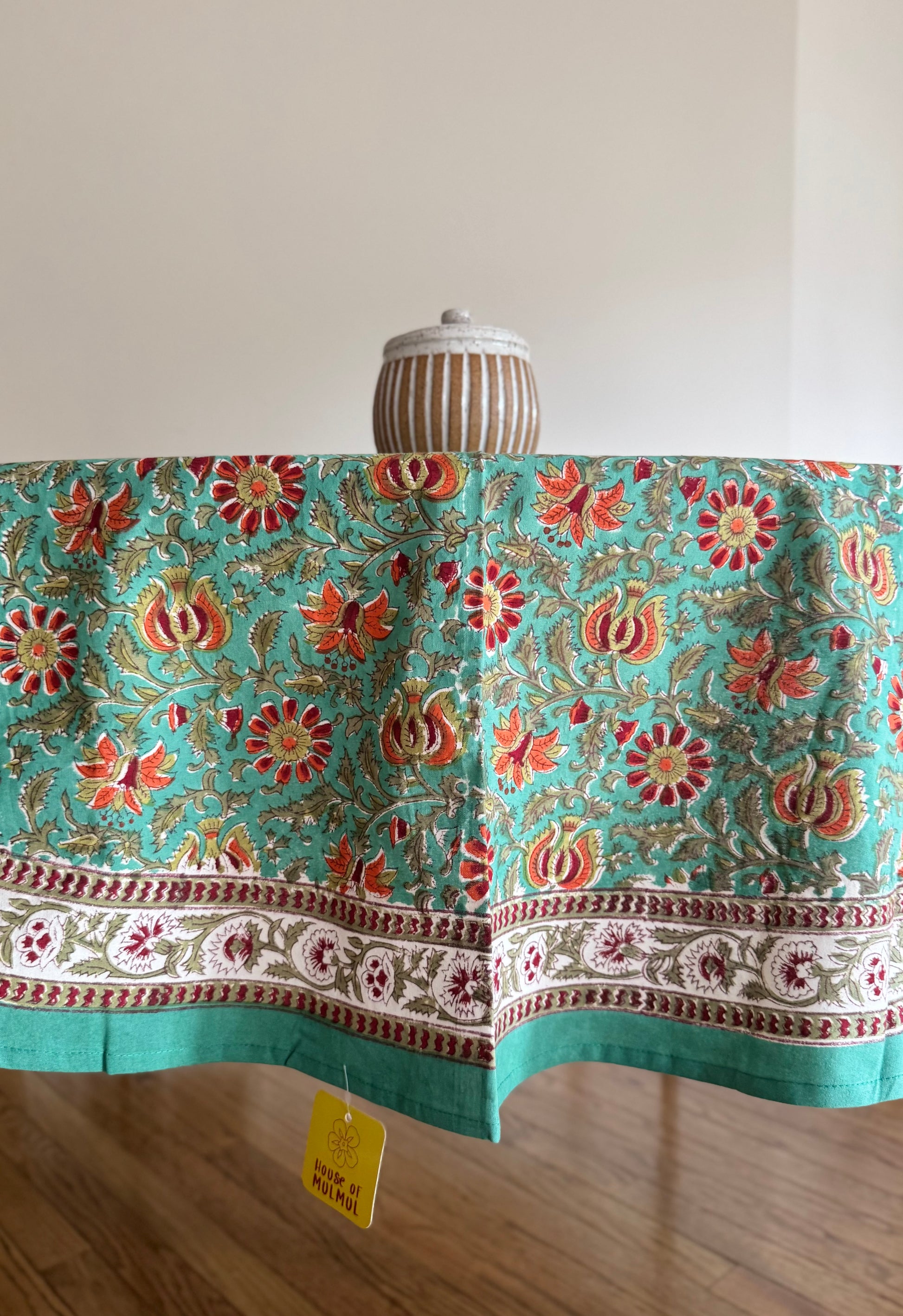 House of Mulmul - Cotton Table Cloth Round. Decorative tablecloth with floral pattern on a wooden table