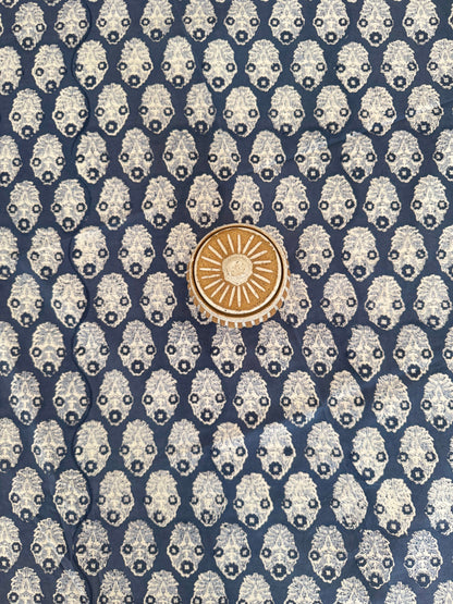 House of Mulmul - Cotton Table Cloth Round. Patterned fabric with a central gold emblem on a blue background