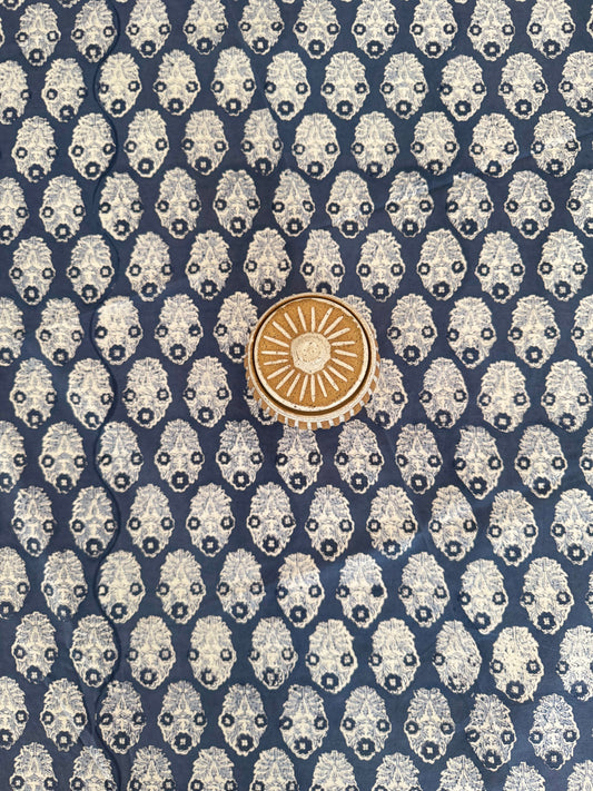 House of Mulmul - Cotton Table Cloth Round. Patterned fabric with a central gold emblem on a blue background